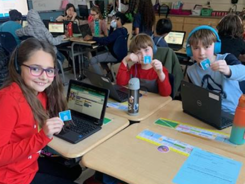 Students holding up their Hour of Code Stickers