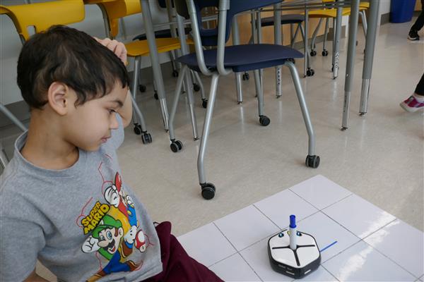 Student looking at robot