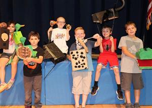Six students showing off puppets they made.